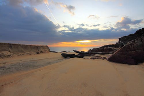 免費 在日落期間的藍雲下的棕色沙子 圖庫相片