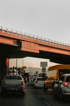 Vehicles line up under an İzmir flyover during evening rush hour, showcasing urban traffic congestion.