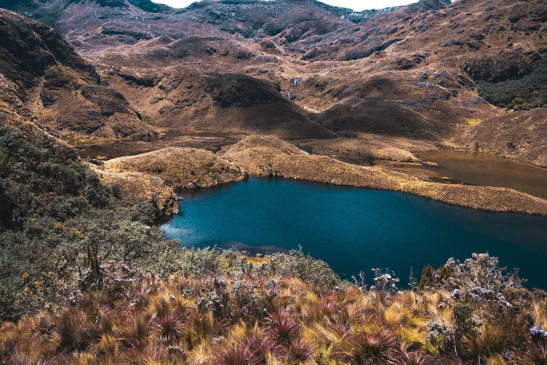 Explore the tranquil beauty of a remote lake nestled amid lush mountains, offering a peaceful escape.