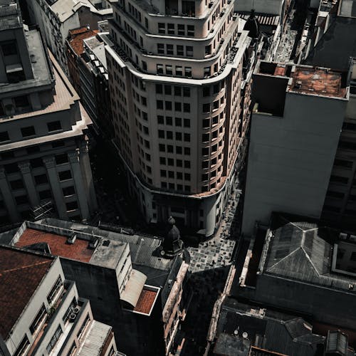 High angle crossing streets of city center surrounded with modern buildings in sunlight