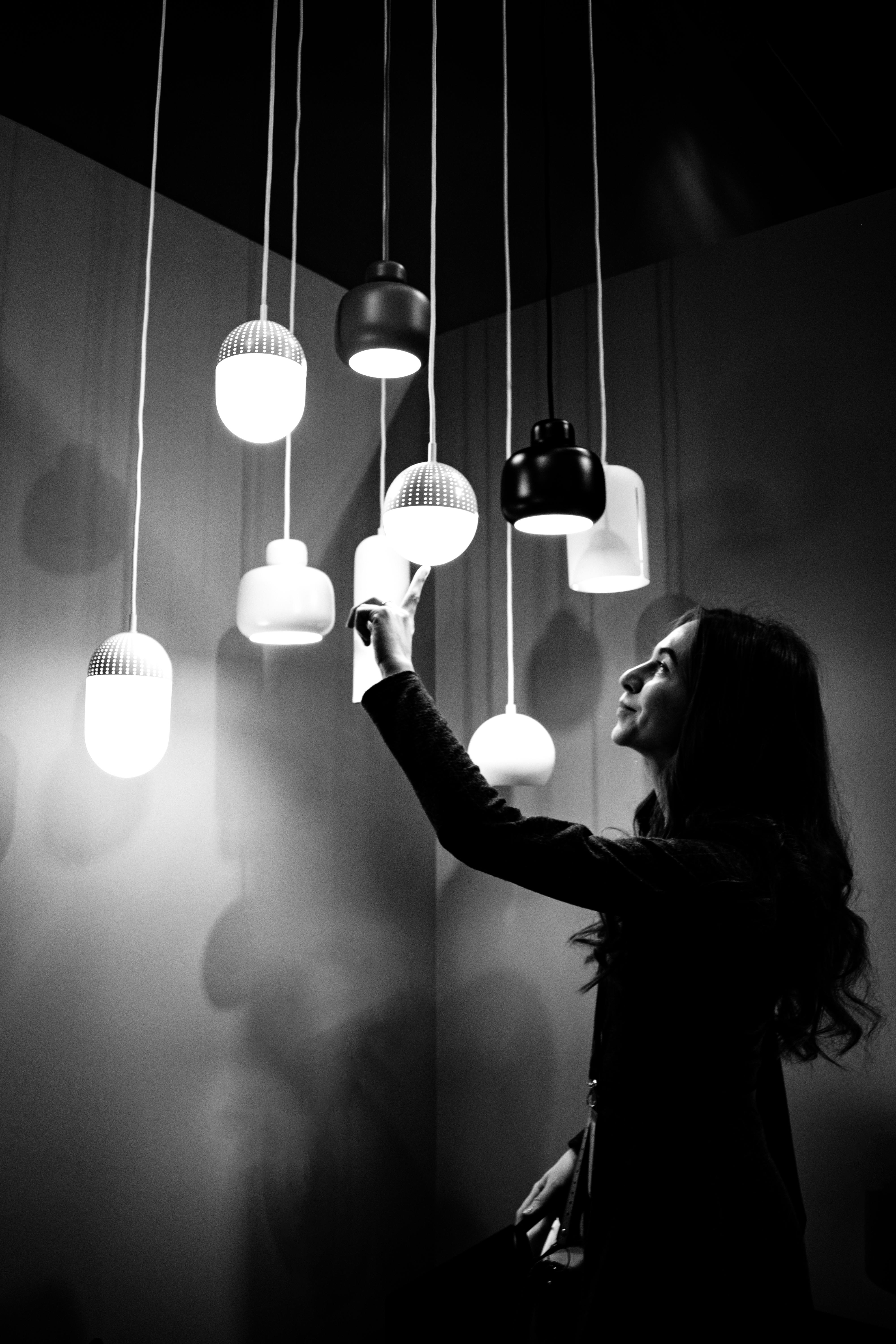 Grayscale Photo of Woman Touching Pendant Lights · Free Stock Photo