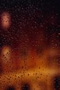 雨滴落在玻璃上，与模糊的城市夜灯共同营造出一种宁静而抽象的氛围