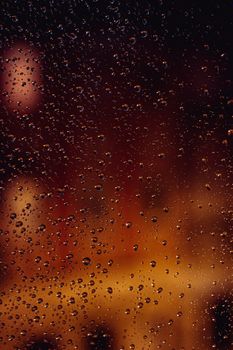 雨滴落在玻璃上，与模糊的城市夜灯共同营造出一种宁静而抽象的氛围