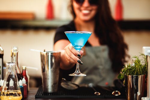 Free Photo of Woman Holding Cocktail Glass With Blue Liquid Stock Photo