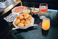 黑色酒吧柜台上，摆放着一盘芳香面包、什锦酱汁和一对鸡尾酒