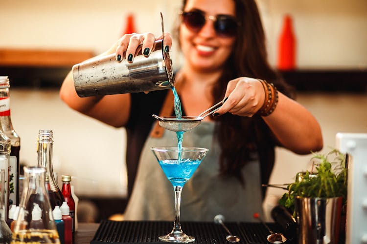 Crop Cheerful Woman Preparing Homemade Blue Cocktail In Bar