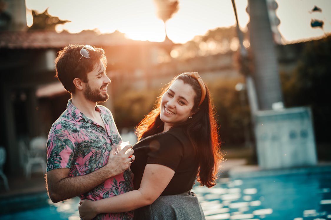 couple smiling near swimming pool