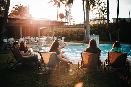 People Sitting on Sunloungers Near Swimming Pool