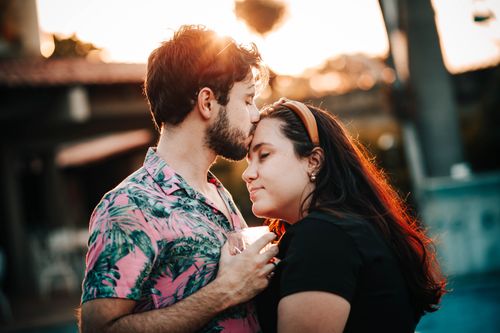 Free A loving couple shares a tender moment outdoors during sunset, symbolizing affection and togetherness. Stock Photo