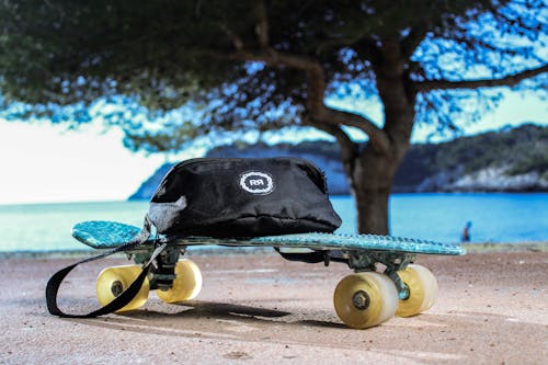 Free Close-Up Photo of a Black Belt Bag on a Penny Board Stock Photo