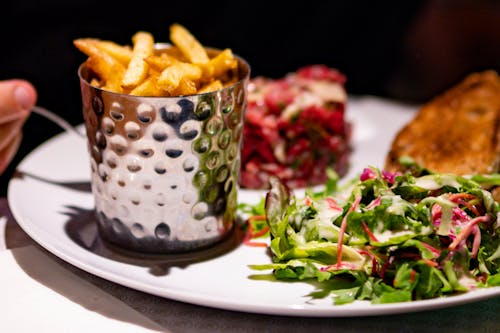 Close-Up Photo of Salad and Fries on White Plate