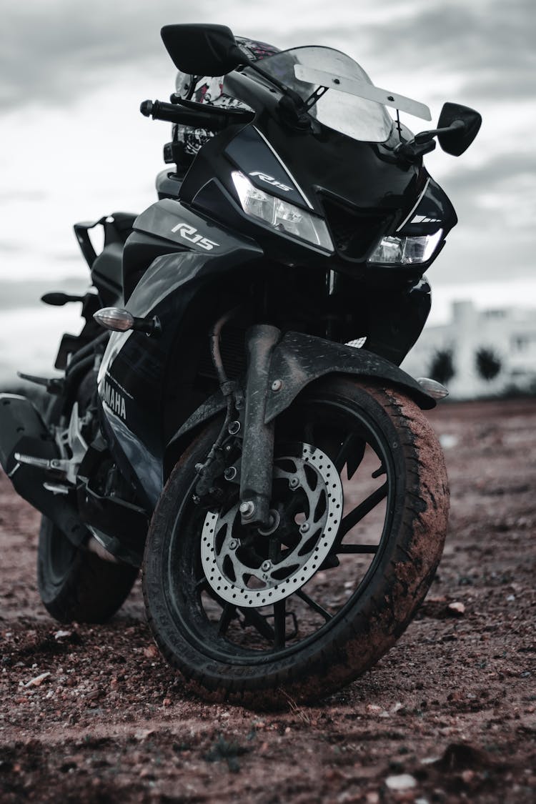 Black Motorcycle Parked On Dirt Road
