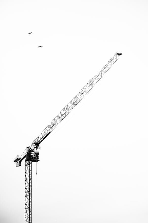Metal crane under sky with long jib