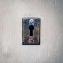 Rusty keyhole with screws on concrete wall