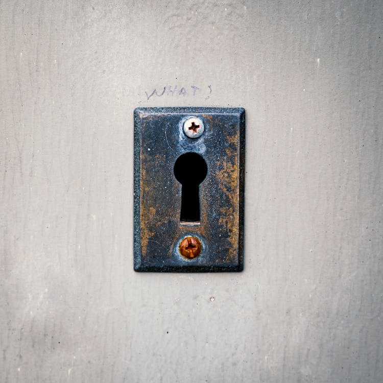 Rusty Keyhole With Screws On Concrete Wall