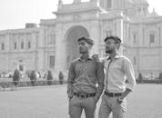Black and white of serious men in casual clothes standing on street and looking away