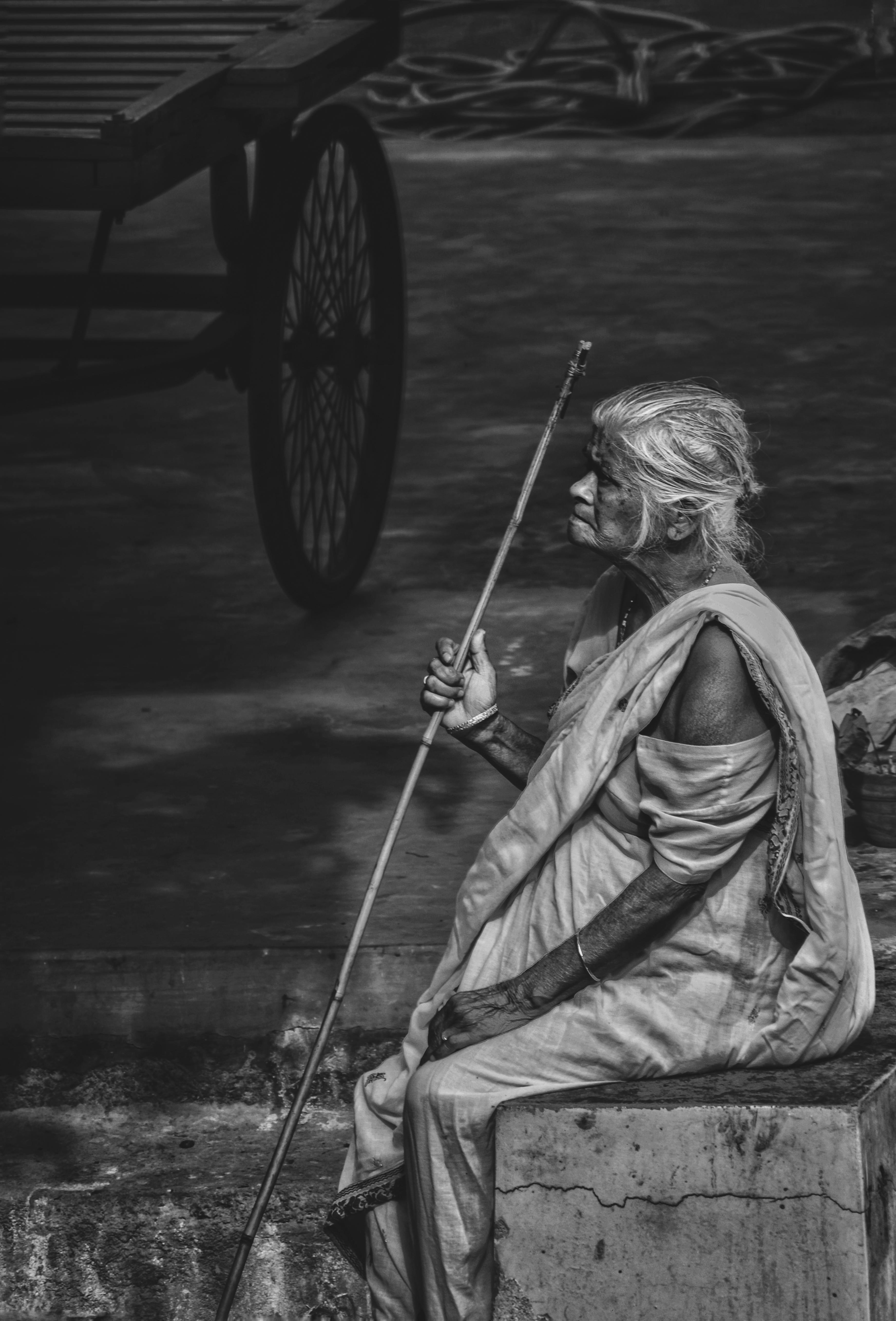 Thoughtful senior ethnic woman resting in old town and looking away