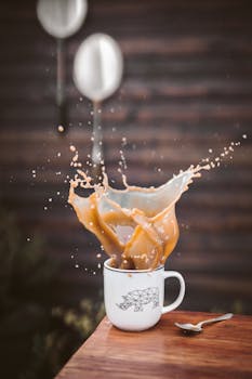 Capture of a vibrant coffee splash in a white mug with geometric bear design, evoking energy and movement.