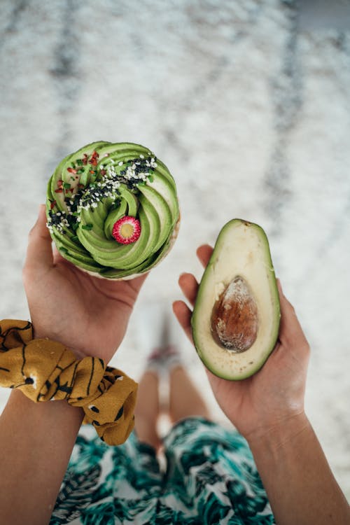 Free Person Holding a Slice of Avocado Stock Photo
