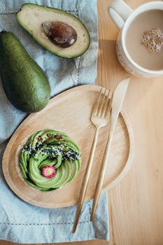 A stylish avocado toast breakfast served with a cup of coffee and golden cutlery.