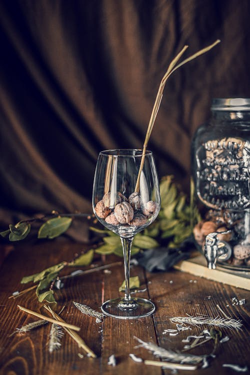 Walnuts placed in glass and jar and placed on wooden table