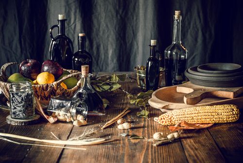 Free From above of different glass bottles with various liquid products and fruit basket on wooden table arranged with fresh corn and peanuts Stock Photo