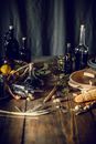 From above of bottles with assorted oil and vinegar placed on wooden table in kitchen near fruit basket composed with corn and herbs