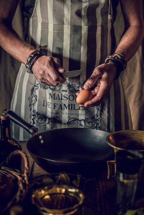 Anonymous male chef cooking egg dish in kitchen