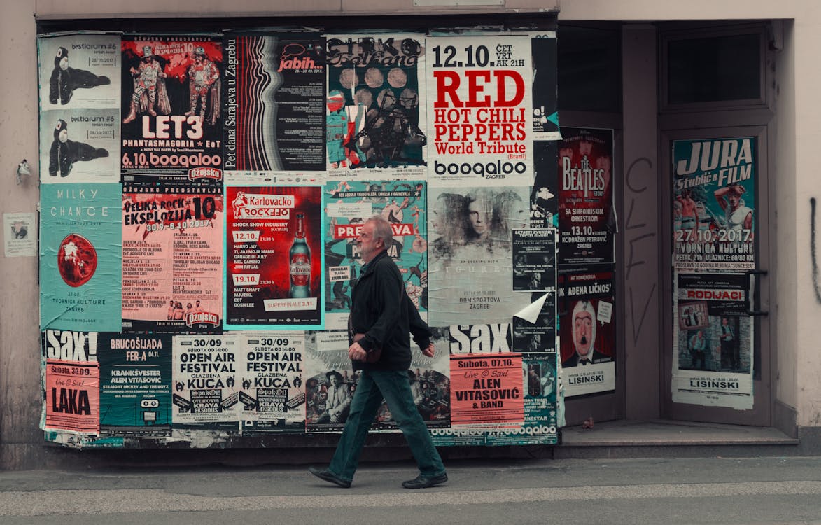Old man walking near board with posters on street · Free Stock Photo