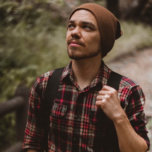 Free Man Wearing Backpack Beside Plant Stock Photo