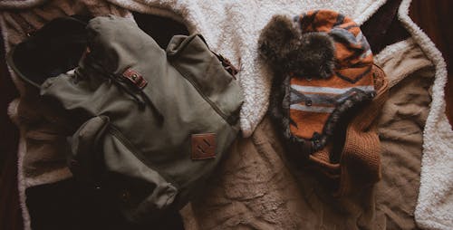 Gray Backpack Beside Orange Knit Hat
