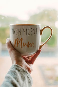 一只手拿着杯子的特写，上面写着“美丽的妈妈”，非常适合母亲节