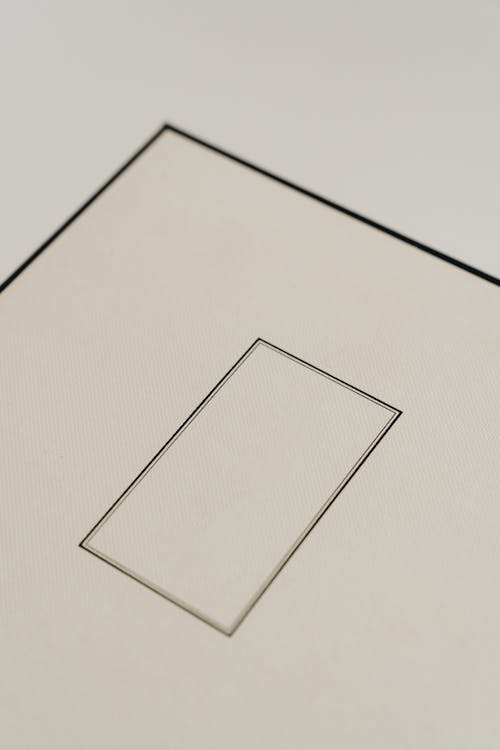 Top view closeup of big square cardboard gift box with smooth surface and small rectangular frame in center with black lines on edges