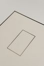 Top view closeup of big square cardboard gift box with smooth surface and small rectangular frame in center with black lines on edges