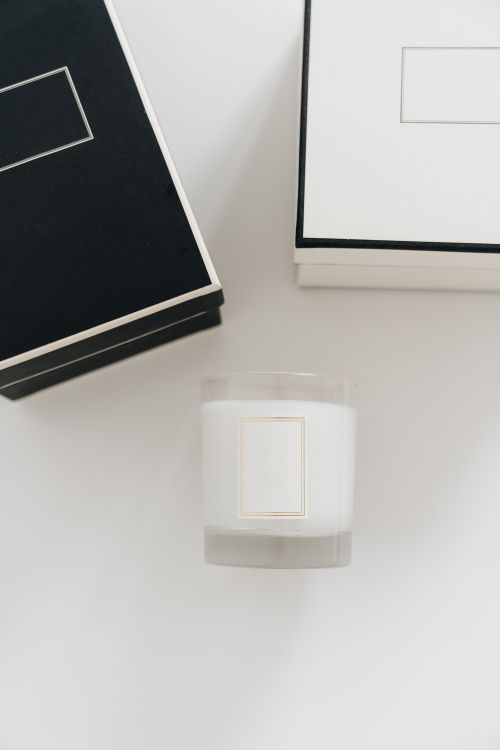 Free A modern minimalist composition featuring a candle and elegant boxes in black and white. Stock Photo