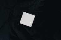Top view of small white square carton present box with smooth surface and dense texture on black background