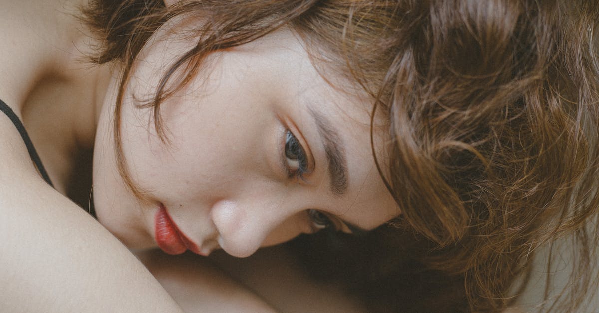 Close-up portrait of a woman deep in thought, showcasing her natural beauty and expressive emotion.