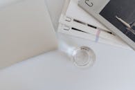 A Magazines and Laptop on the Table Near the Drinking Glass