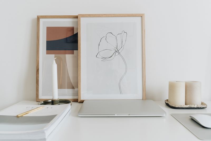 small framed photos lined up on a shelf behind a desk chair