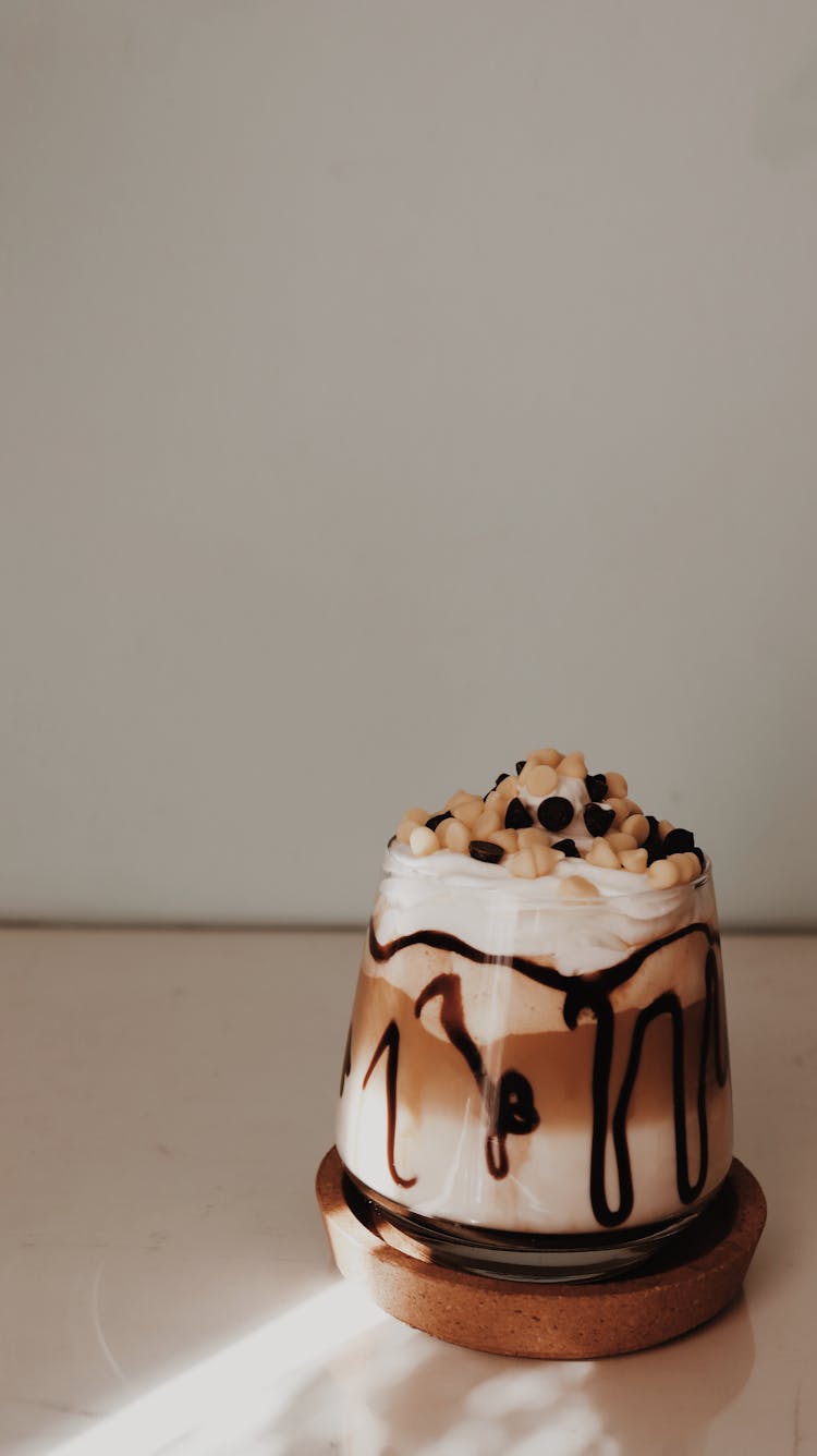 A Sweet Chocolate Drink With Toppings On Clear Glass