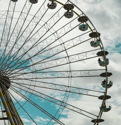 A Low Angle Shot of a Ferris Wheel Under the Blue Sky and White Clouds