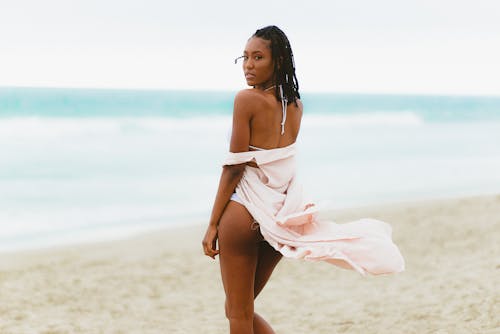 무료 해변 모래에 서있는 여자 스톡 사진