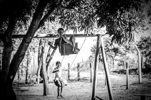 Free Children on swings in summer garden Stock Photo