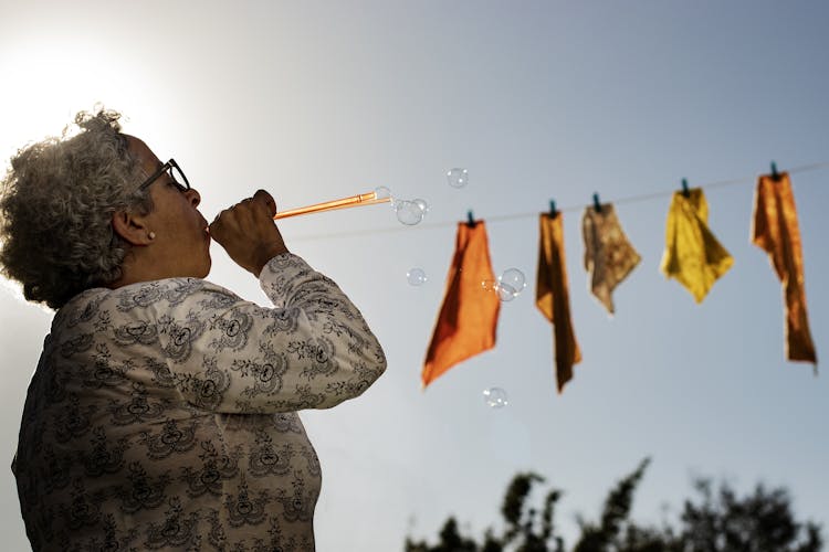 An Elderly Woman Blowing Bubbles