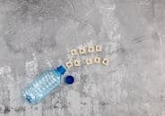 Cubes with letters and plastic bottle with spilled water