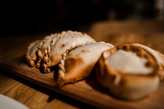 A delicious batch of traditional Argentinian empanadas on a wooden board.