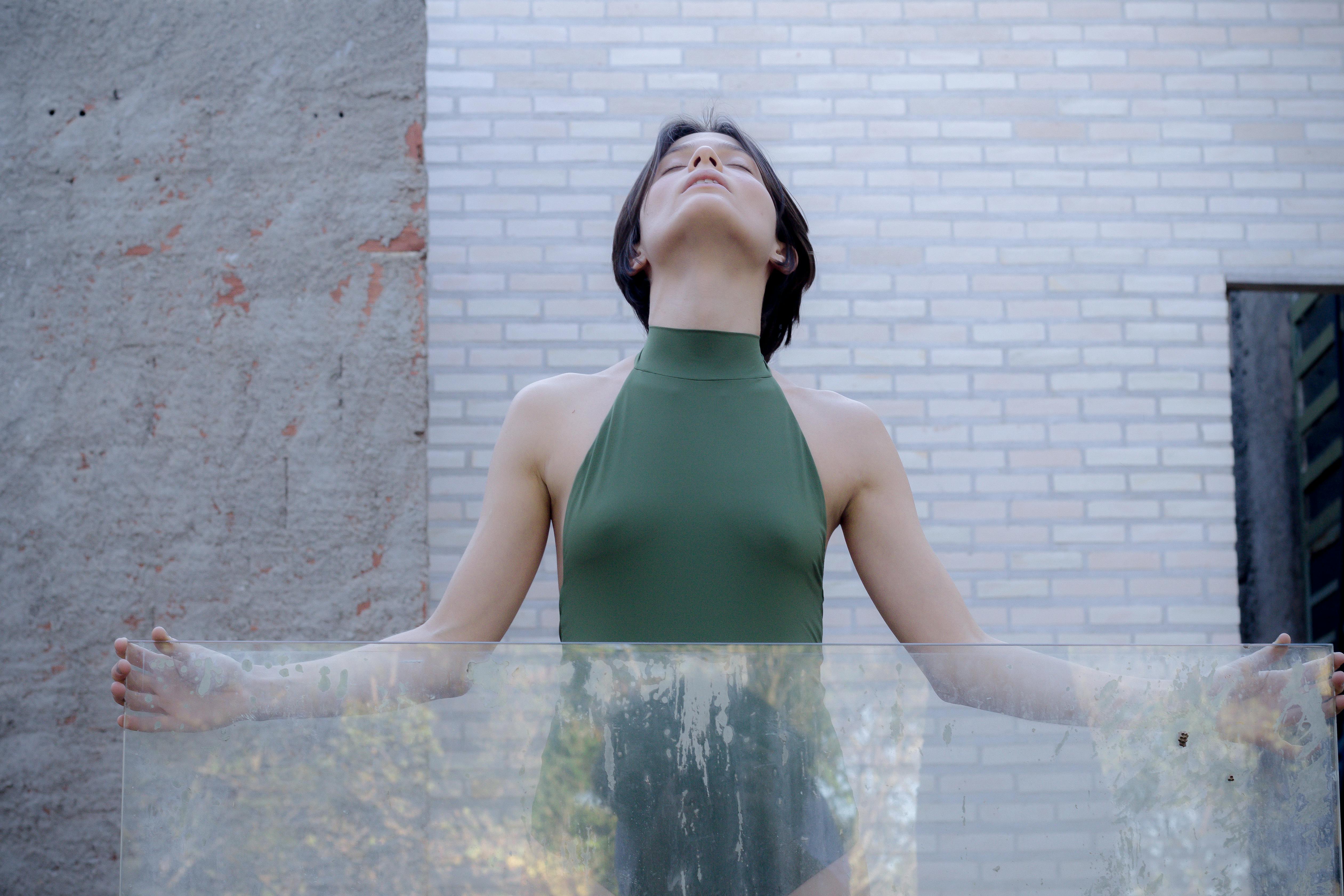 woman in bodysuit holding dirty glass on abandoned site