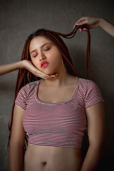 一位年轻女子闭着眼睛，辫子被轻轻抚摸，肖像宁静