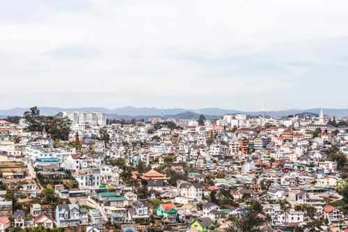 Free Aerial view of Dalat showcasing diverse architecture and hilly landscape under a clear sky. Stock Photo
