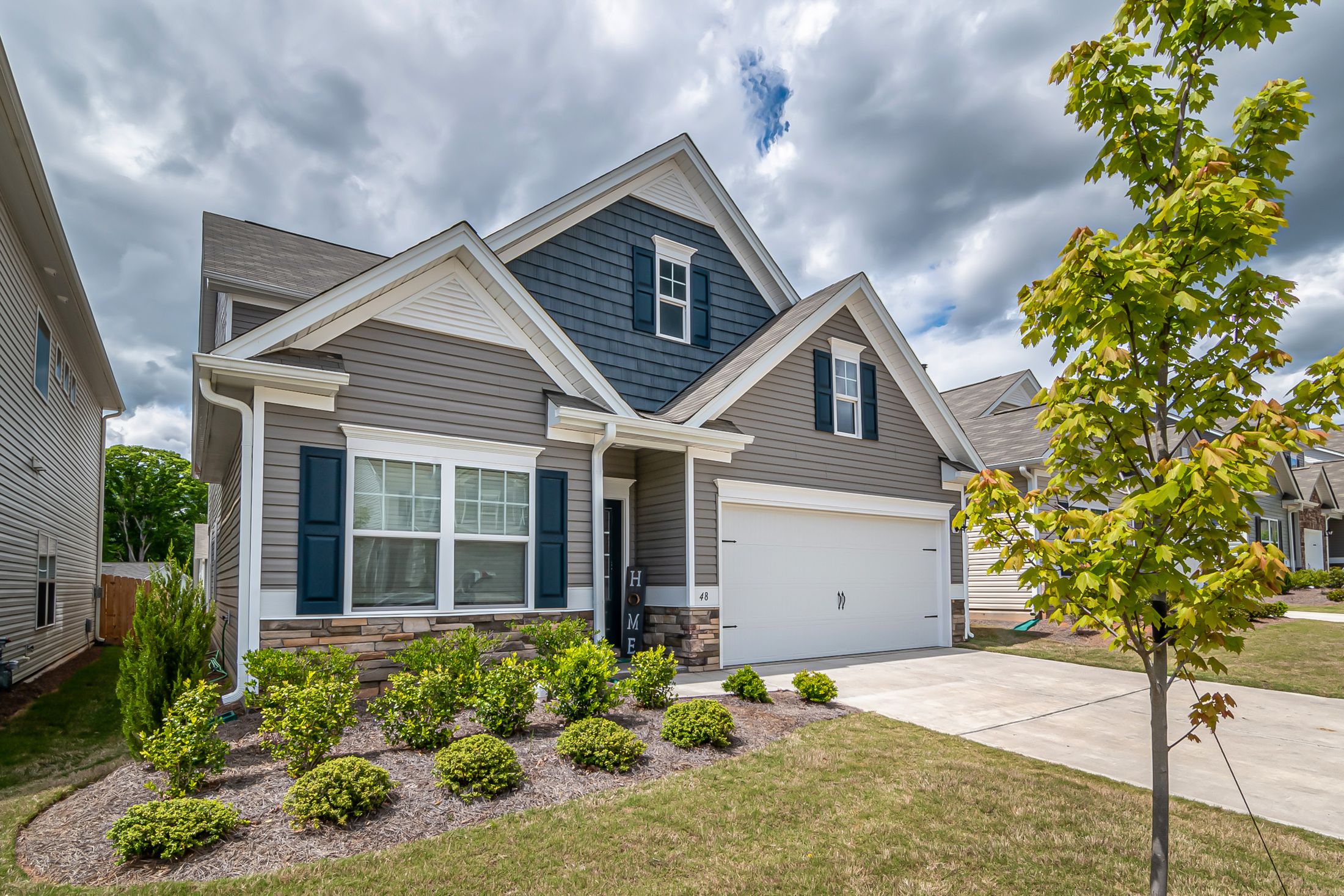 Finished white and gray residential exterior with coordinated siding, windows and landscaping